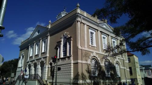Historic building with ornate architecture, large windows, and a blue sky in the background.