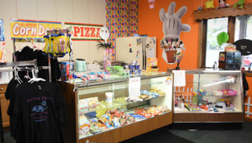 A colorful shop interior featuring snack displays, merchandise, and a vibrant decor with playful character motifs.