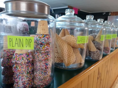 Jars filled with ice cream cones: plain dip with sprinkles, waffle cones, and various coated options.
