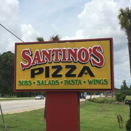 Sign for Santino's featuring "Pizza," "Subs," "Salads," "Pasta," and "Wings" against a cloudy sky backdrop.