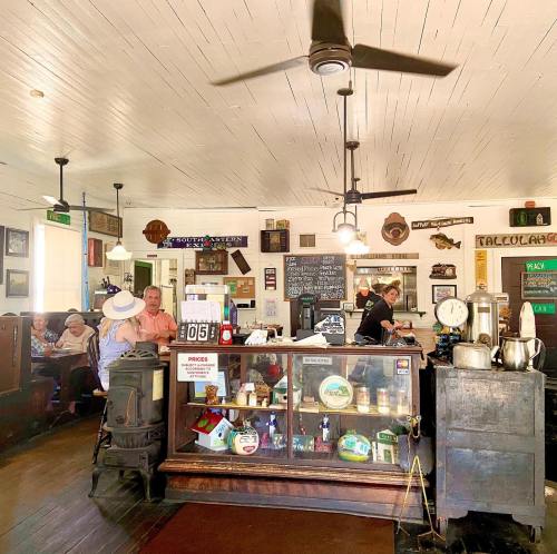 A cozy café interior with vintage decor, a counter, and patrons enjoying their meals in a warm atmosphere.