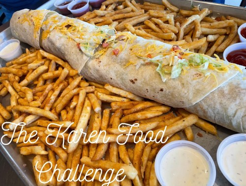 A large burrito surrounded by a mountain of French fries, with dipping sauces on the side, labeled "The Karen Food Challenge."