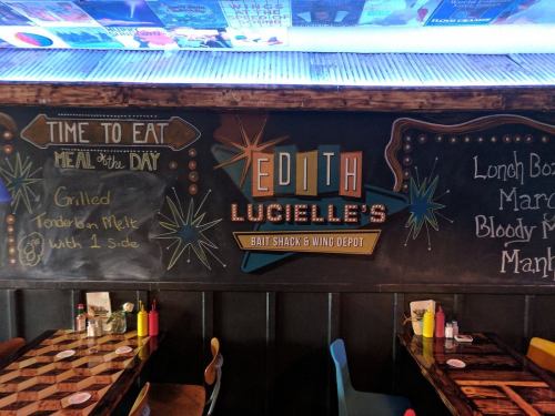 Chalkboard menu at Edith Lucielle's featuring daily specials and colorful decor in a casual dining setting.