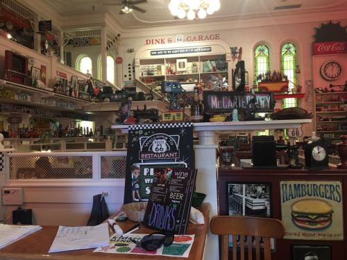 A vintage diner interior filled with memorabilia, signs, and decorations, showcasing a nostalgic Route 66 theme.