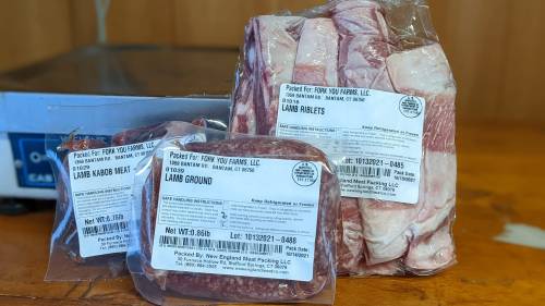 Packages of various cuts of lamb meat, including riblets, ground lamb, and kabob meat, with labels visible.