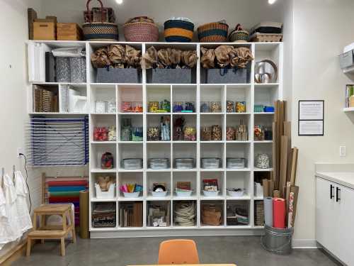 A neatly organized shelving unit filled with various craft supplies, baskets, and materials in a bright workspace.