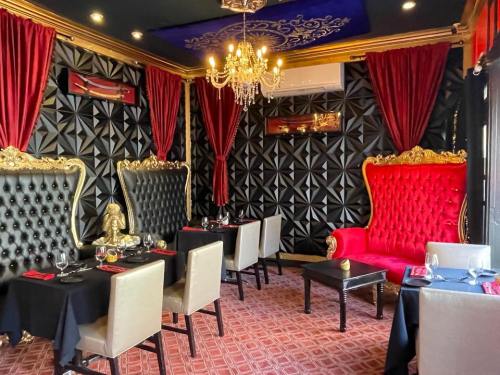 Elegant restaurant interior featuring plush seating, black and red decor, and a chandelier.