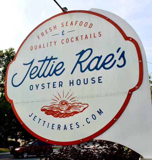Sign for Jettie Rae's Oyster House featuring fresh seafood and quality cocktails, with a logo of an oyster.