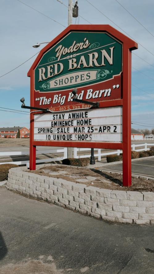Sign for Yoder's Red Barn Shoppes featuring a spring sale announcement and details about unique shops.