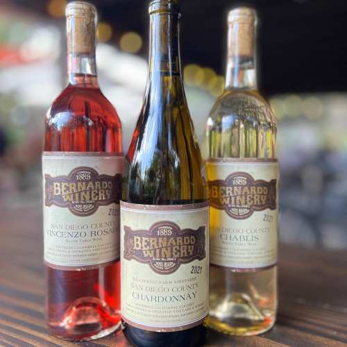 Three wine bottles from Bernardo Winery: a rosé, a Chardonnay, and a Chablis, all labeled with vintage and region details.