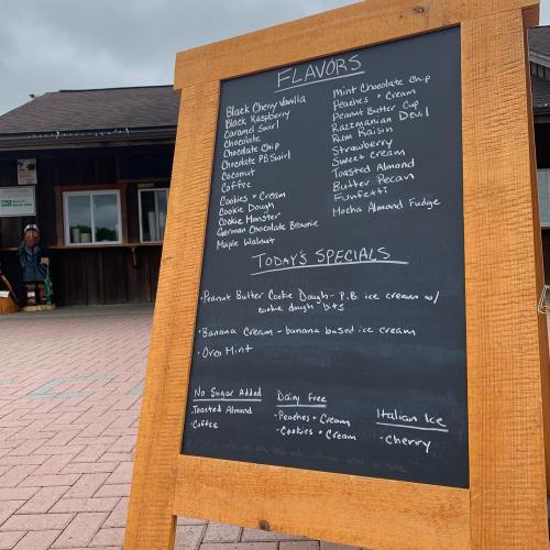 A chalkboard menu displaying ice cream flavors and daily specials, including peanut butter and Oreo mint options.