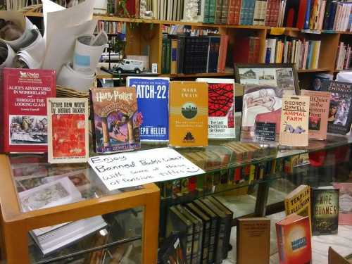 A display of banned books on a table, featuring titles like "Harry Potter," "Catch-22," and "Animal Farm."