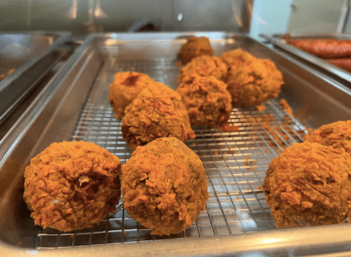 Golden-brown, crispy fried balls arranged on a wire rack, showcasing a textured, crunchy exterior.