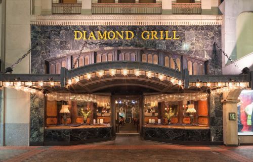 Exterior of Diamond Grill restaurant, featuring elegant lighting and a marble facade with a welcoming entrance.