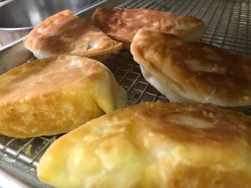 Golden, flaky pastries arranged on a wire rack, showcasing a crispy exterior and soft interior.