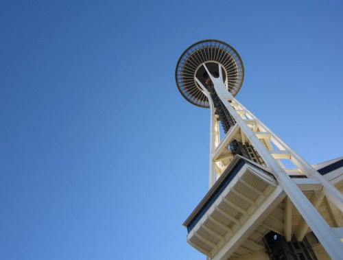 A low-angle view of the Space Needle against a clear blue sky.