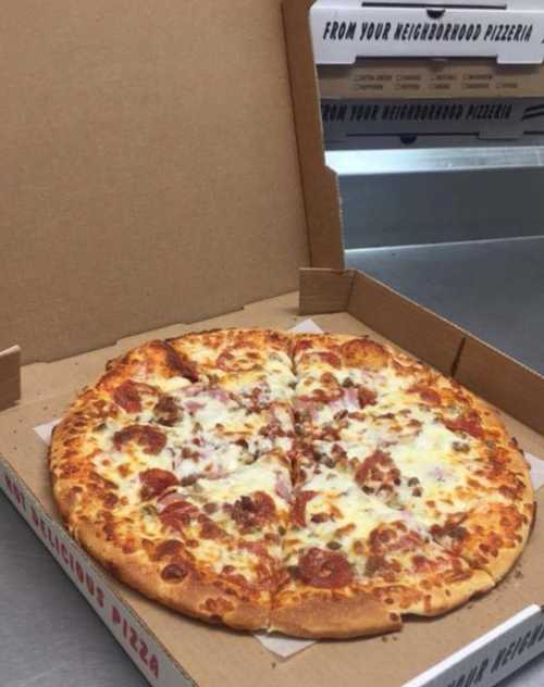 A large pizza with pepperoni and cheese in an open pizza box on a countertop.