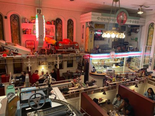A vintage-themed diner with retro decor, neon signs, and customers enjoying meals in a lively atmosphere.