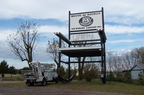 A giant rocking chair sign for Route 66, labeled "World's Largest," with a utility truck nearby.