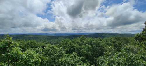 A panoramic view of lush green hills under a partly cloudy sky.