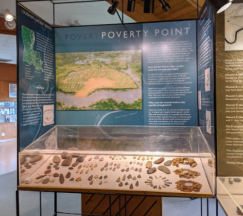 Exhibit display on Poverty Point, featuring artifacts and an aerial view of the site in Louisiana.