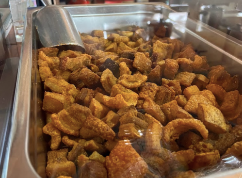 A metal tray filled with crispy, golden-brown pork cracklings.