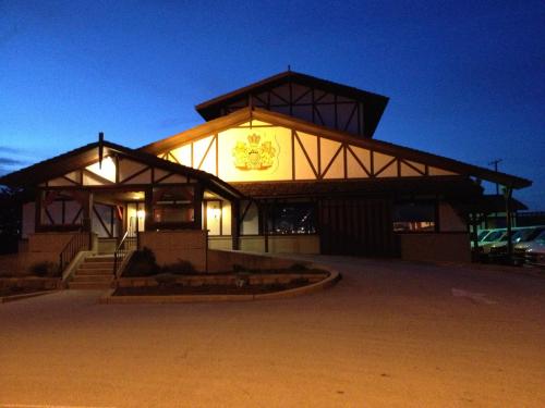 A large, rustic building with a peaked roof and decorative signage, illuminated at dusk.