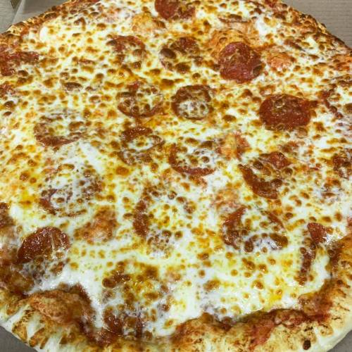 A close-up of a pepperoni pizza with melted cheese and a golden-brown crust, placed in a pizza box.