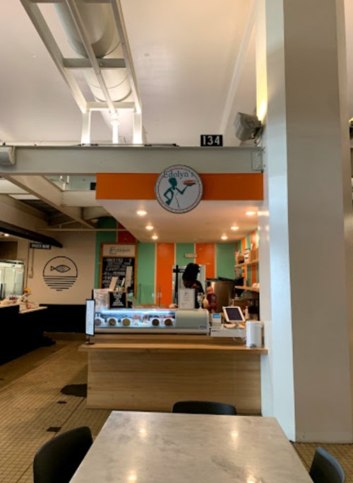 A brightly colored ice cream shop with a sign reading "Evelyn's" and a display of ice cream in a modern setting.