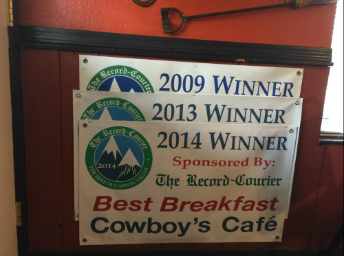 Banners displaying awards for "Best Breakfast" at Cowboy's Café from 2009, 2013, and 2014, sponsored by The Record-Courier.