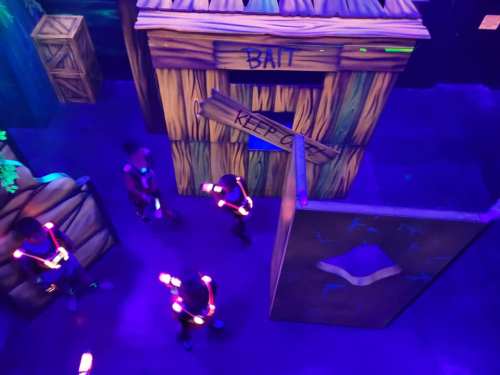 A colorful indoor space with glowing figures and wooden structures labeled "Bait" and "Keep Out."