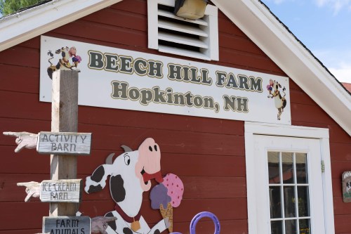 Sign for Beech Hill Farm in Hopkinton, NH, featuring a cow and directions to activity and ice cream barns.