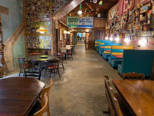 Interior of a rustic restaurant with colorful booths, wooden tables, and walls adorned with photos and memorabilia.