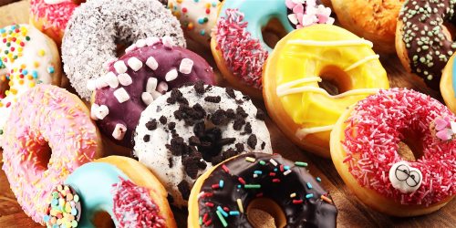 A colorful assortment of donuts with various toppings, including sprinkles, icing, and chocolate.