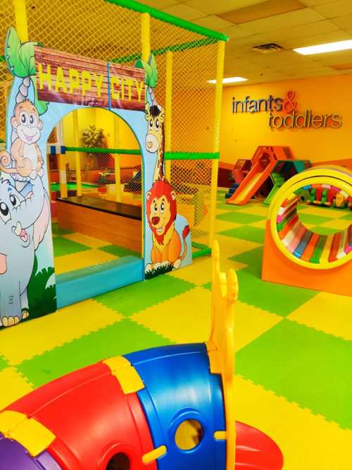 Colorful indoor play area for infants and toddlers, featuring a jungle theme with slides and climbing structures.