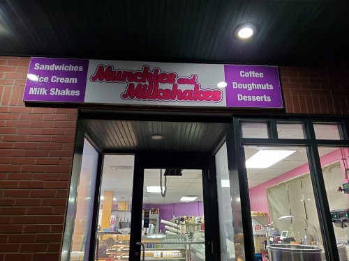 Sign for "Munchies and Milkshakes" featuring sandwiches, ice cream, milkshakes, coffee, doughnuts, and desserts.