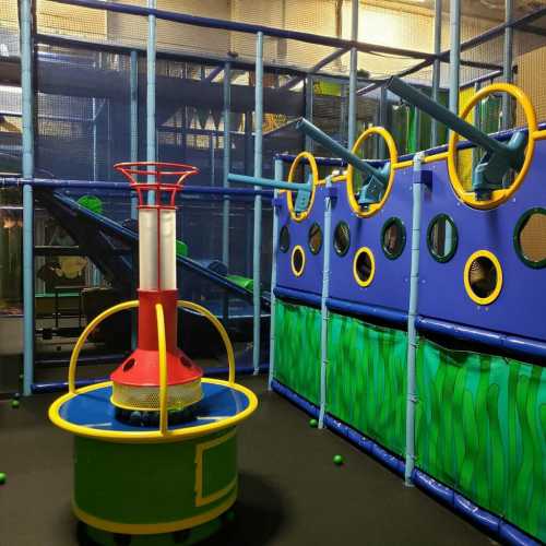 Colorful indoor playground with climbing structures, slides, and interactive features for children.