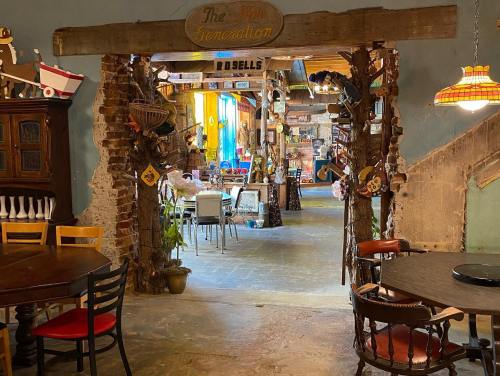 A cozy, rustic café entrance with wooden decor, colorful lights, and tables visible in the background.