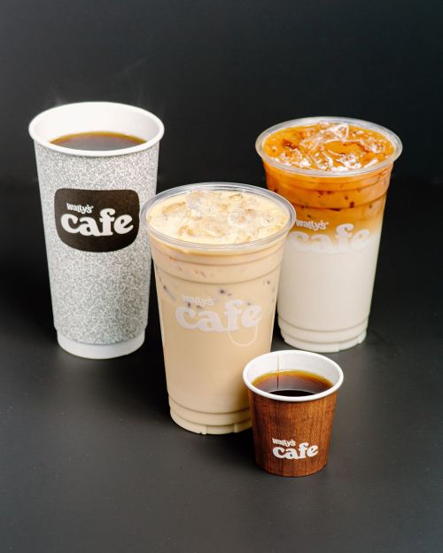Four coffee drinks from Wally's Cafe: a hot cup, two iced options, and a small espresso cup, all on a dark background.