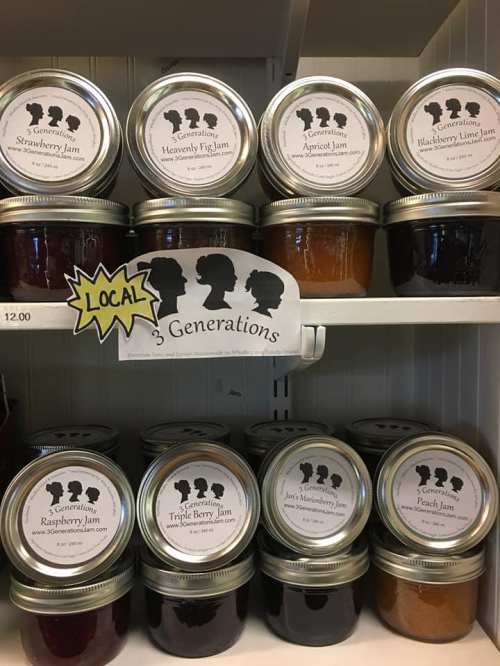 Shelves displaying jars of various jams labeled "3 Generations," with a sign highlighting "LOCAL" products.