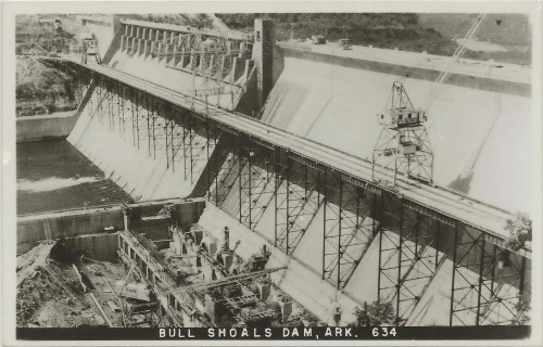 Black and white photo of Bull Shoals Dam in Arkansas, showcasing its massive structure and surrounding landscape.