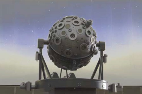 A spherical planetarium projector with a textured surface, set against a starry sky backdrop.
