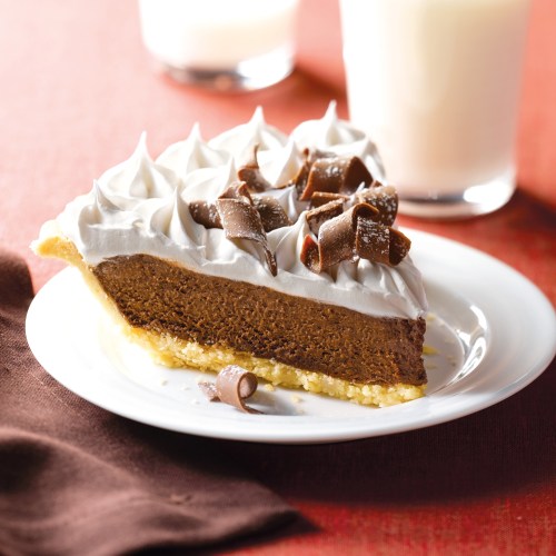 A slice of chocolate cream pie topped with whipped cream and chocolate curls, served on a white plate.
