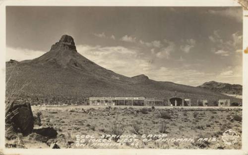 Black and white photo of Cool Springs Garage with a mountain backdrop, along Route 66 in Kingman, Arizona.