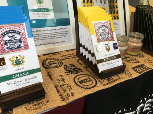 Display of chocolate bars from Ghana and Ecuador, featuring 70% dark chocolate, on a decorative tablecloth.