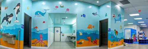 Colorful underwater-themed restroom with murals of sea creatures and a bright, inviting atmosphere.