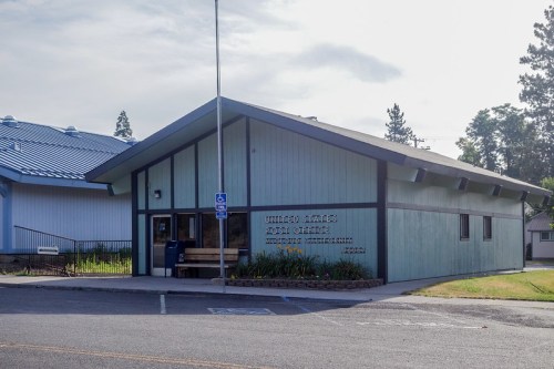 A single-story building with a sloped roof, labeled "United States Post Office," surrounded by greenery.