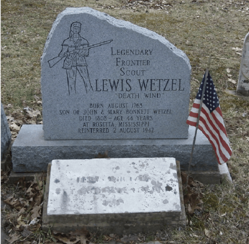 Gravestone of Lewis Wetzel, a legendary frontier scout, with an American flag and a soldier engraving.