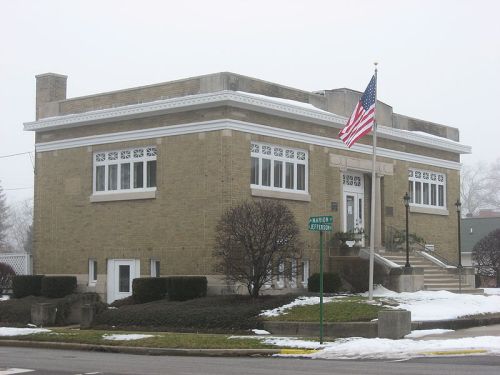A brick building with large windows, an American flag, and snow on the ground, located at the corner of Madison and Jefferson.