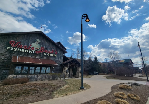 Exterior of Uncle Buck's Fishbowl & Grill, featuring a rustic design and a cloudy sky in the background.